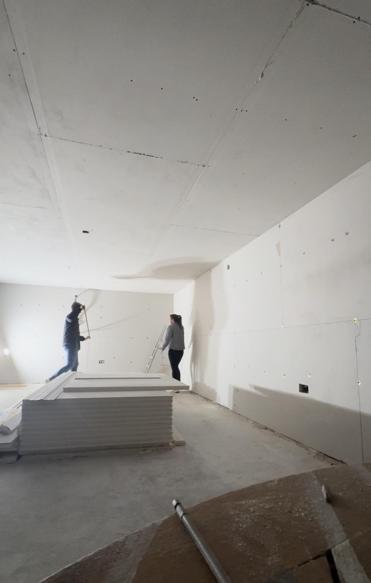 Erin in the roastery while it is being built, with plasterboard stacked on the floor