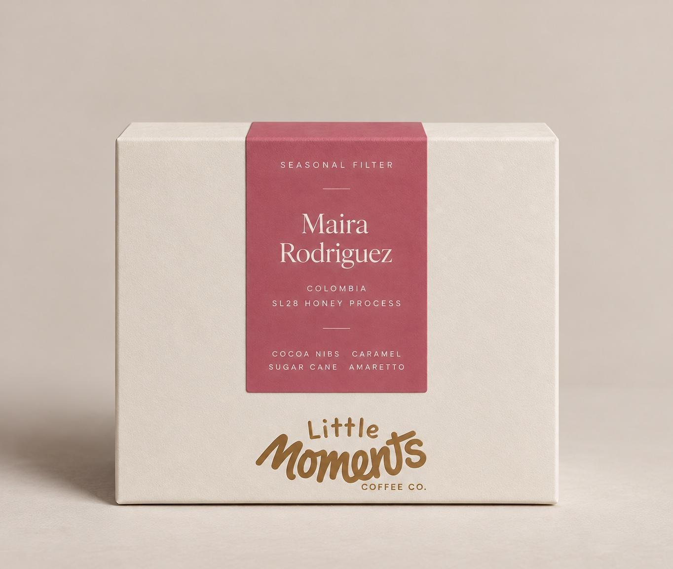 A cream Little Moments box with a pink Seasonal Filter label for Maira Rodriguez